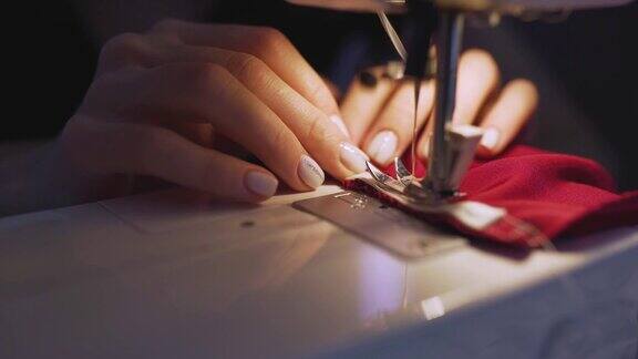 女性的手在缝纫机上工作的特写镜头年轻的女性概念设计师在家里用缝纫机工作时尚和裁剪