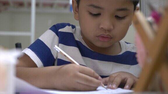 男孩在书桌上做作业的特写