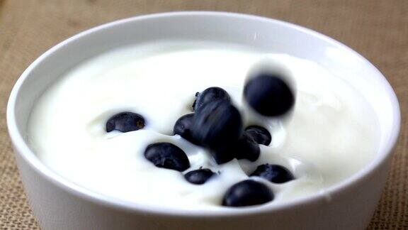 蓝莓落入酸奶中慢动作溅起水花早上的早餐