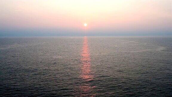 梦幻般的日落在波浪的海面上从开放的甲板上看移动的巡洋舰