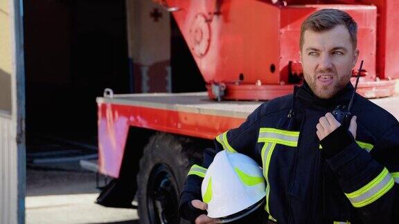 勇敢的消防员对着对讲机说话背景是消防车拯救生命的理念英雄的职业消防安全