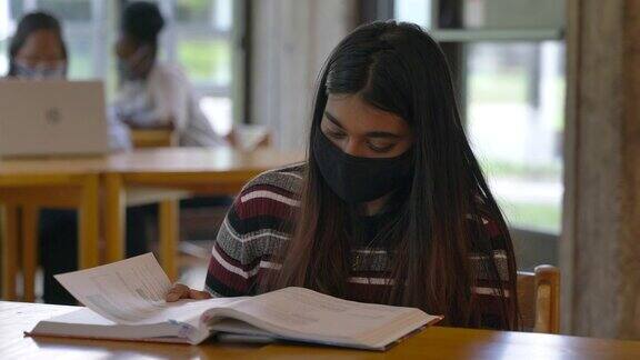 在校园里学习的大学生戴着口罩