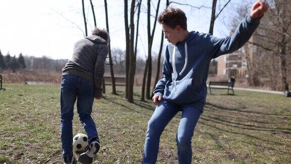 十几岁的男孩在公园里踢足球