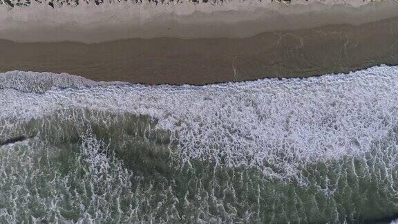 俯视图“鸟瞰”海浪的鸟瞰图太平洋沿岸的海滩美国加利福尼亚州用静态摄像机拍摄无人机视频