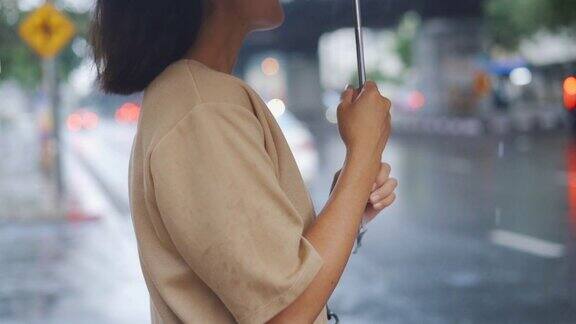 女人在雨中撑伞的慢动作