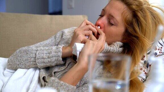 一名发烧妇女使用喷鼻剂并打喷嚏