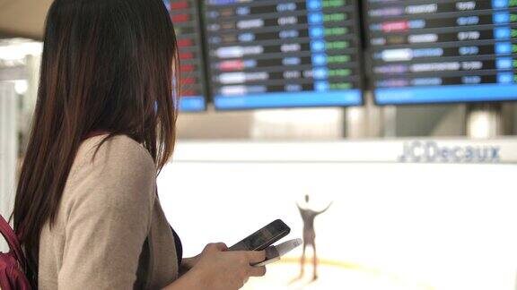 一名女子在机场用智能手机检查登机牌