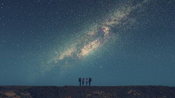 四个朋友站在山顶上星空为背景