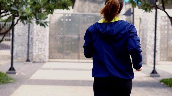 慢镜头年轻的亚洲女子在公园慢跑