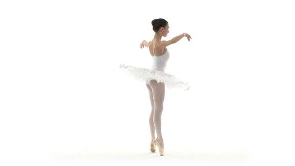 一名芭蕾舞演员在白色背景下慢动作地跳着白色芭蕾舞裙