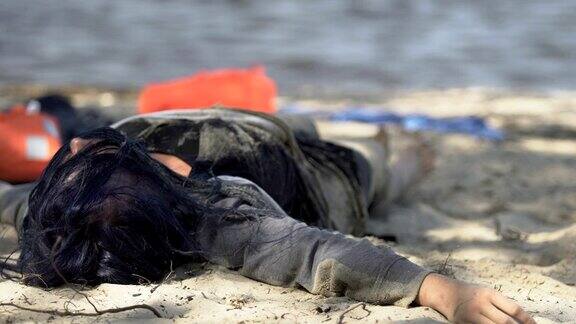 沉船后女难民咳嗽几乎不能呼吸躺在海滩上