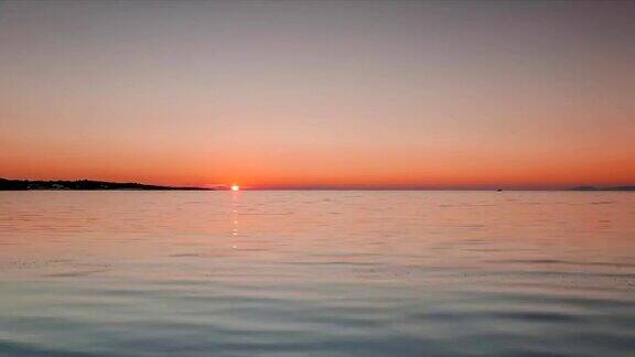 平静的海面上有渔船在夕阳下FullHD时间流逝