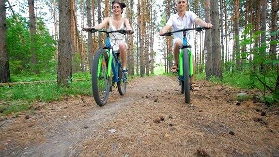 白种年轻夫妇享受在森林里骑自行车的乐趣