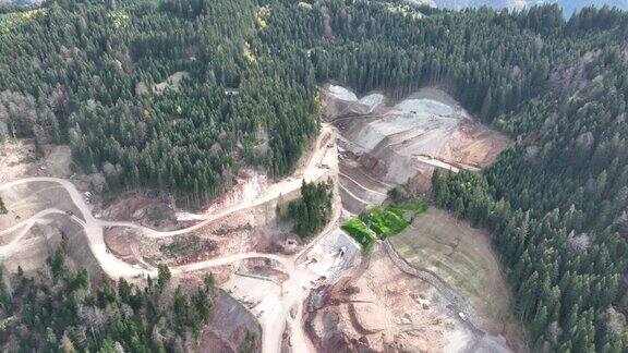 工业矿山挖掘机正在施工现场挖土装载卡车无人机俯视图