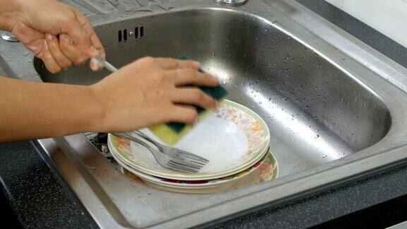 在水槽中擦洗盘子