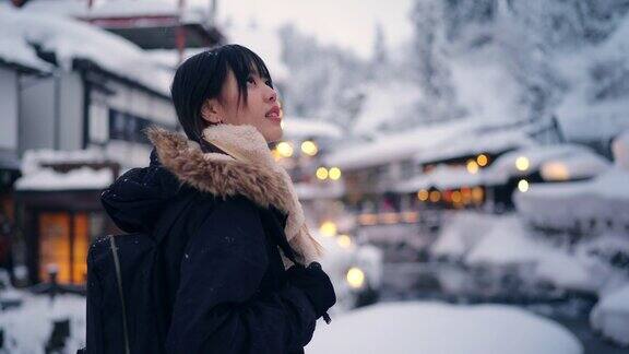 4K年轻的亚洲女子在下雪天在银山温泉区旅行