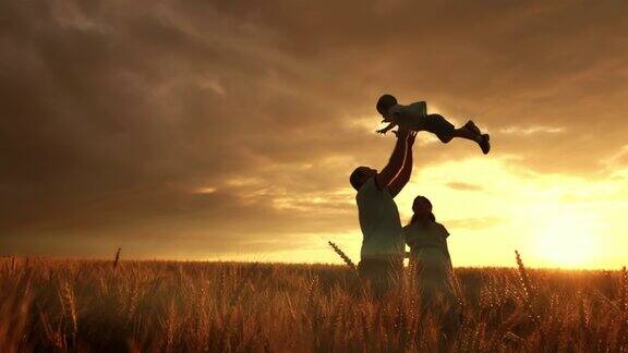 夕阳西下时父亲正在田野上把他的儿子抛向天空
