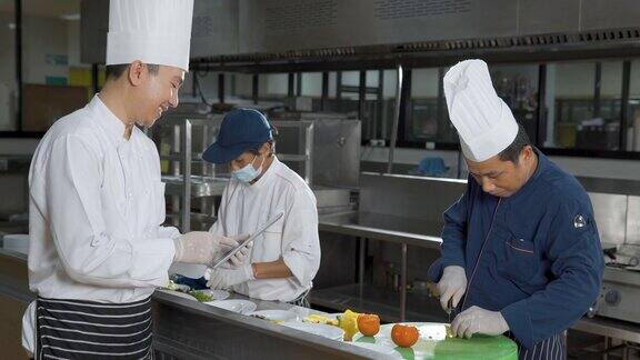 在酒店餐厅厨房里准备食物的厨师团队食物和丁克概念