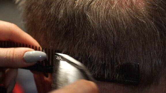 女理发师用电动剪子给男人理发