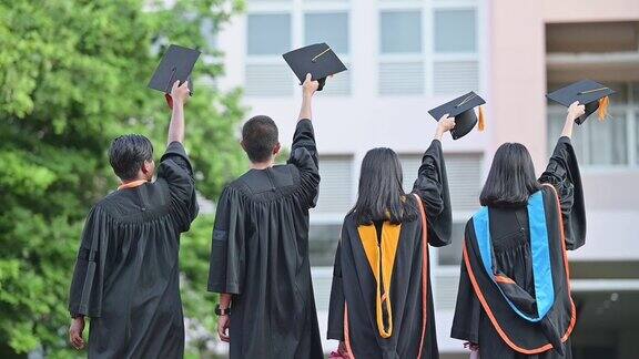 大学毕业生在毕业典礼上举起帽子祝贺他们