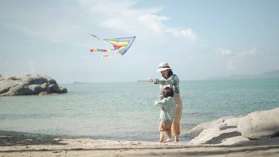 妈妈和儿子在沙滩上玩风筝