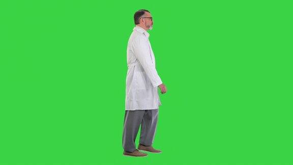成熟的医生医生在绿色屏幕上孤立行走色度键