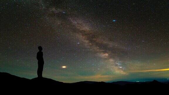 孤独的人站在繁星满天的山顶间隔拍摄