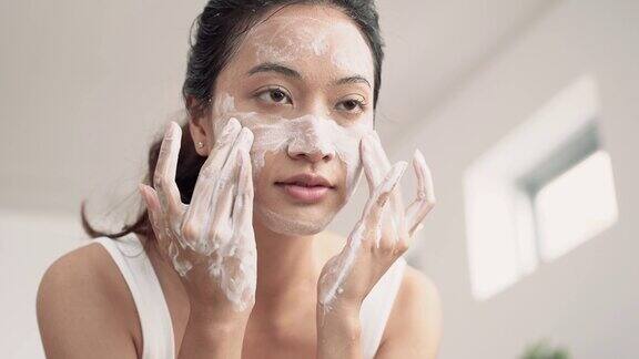 美丽的亚洲女性用水洗脸洗脸