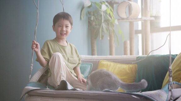 小男孩和他的猫在家里玩