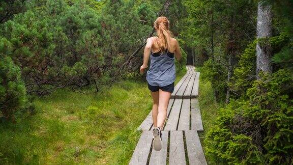 健康女性运动员在大自然中跑步穿过树林