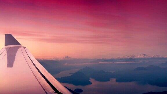 在日出时飞过雪山和湖泊
