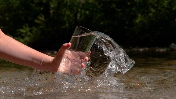 慢镜头:一个面目全非的女人把冰冷的泉水舀进一个空杯子里