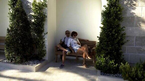 一对老夫妇坐在长椅上欣赏日落