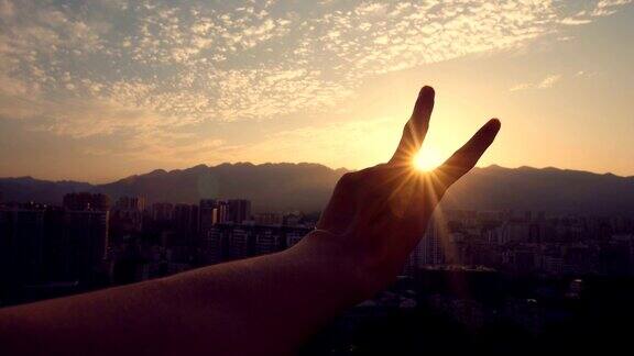 夕阳西下手指做着和平的手势