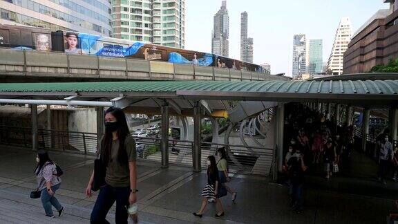 在泰国曼谷的商业中心地区在病毒爆发和PM2.5空气污染危机高峰期人群戴着防护口罩来预防冠状病毒、冠状病毒19病毒