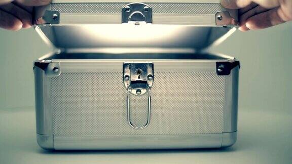 一名男子打开一个金属手提箱从手提箱里射出一束白光