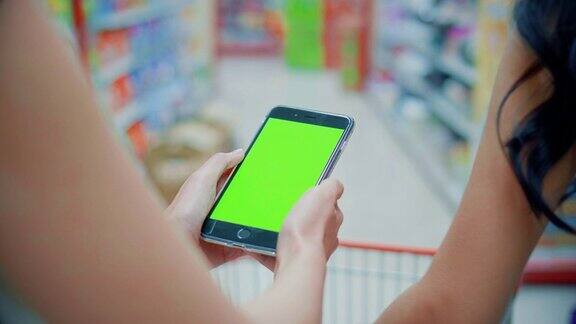 两名年轻女性在超市使用智能手机绿屏