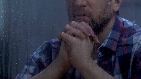 中年男子在雨窗后祈祷上帝希望更好信仰