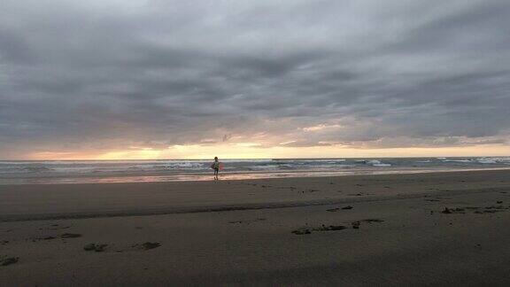 小男孩超级英雄在新西兰穆拉瓦伊海滩玩日落