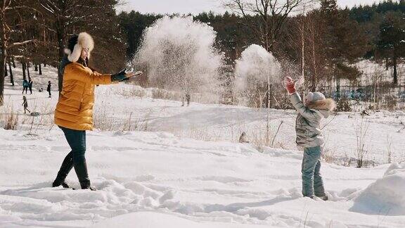 母亲和小女儿玩雪的慢镜头快乐的冬天休息