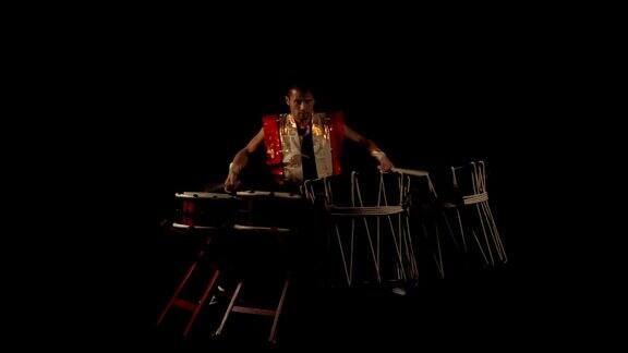 在黑暗的舞台上一个日本鼓手Taiko鼓的全长肖像没有声音