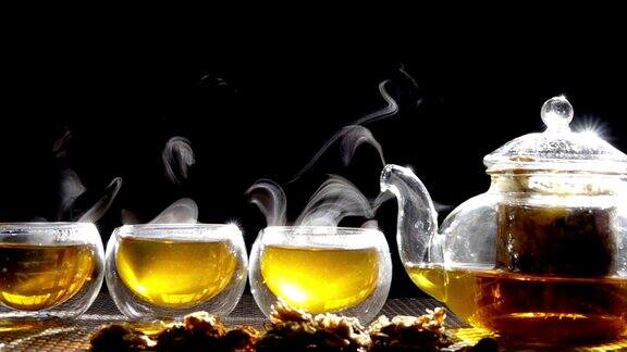 慢镜头热腾腾的菊花茶从一个玻璃罐里倒进一杯热气腾腾的白烟