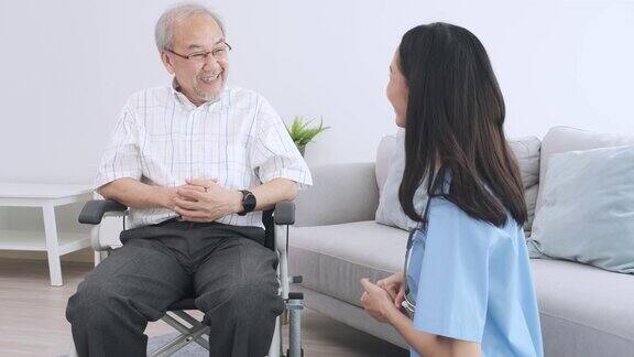 一个亚洲老人拿着一个胶囊和一杯由他的照顾者准备的水饭后服用