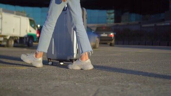 一个女孩提着行李箱在城市里走着