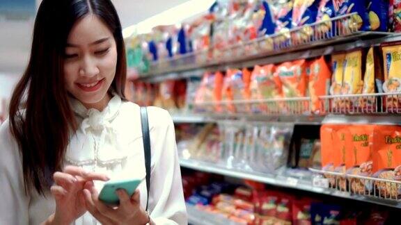 女人在超市用智能手机慢镜头
