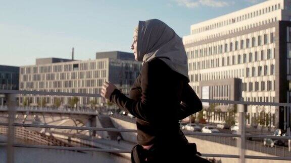 柏林中心的穆斯林妇女戴着头巾跑步的侧面图