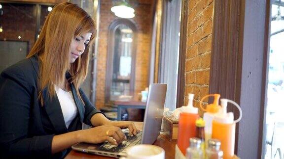 商务女性在笔记本电脑上打字