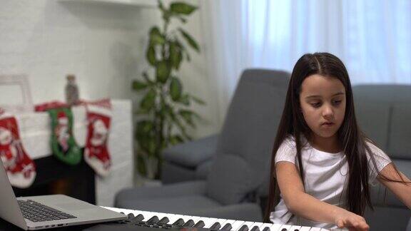 可爱的小女孩在钢琴上弹奏练习