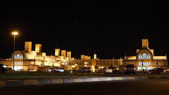 阿拉伯联合酋长国沙迦中央市场夜景汽车开着灯经过照亮建筑建筑的艺术作品市场建设