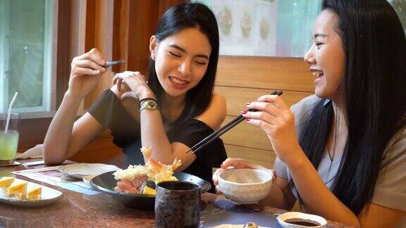两个亚洲女性朋友一起吃饭和吃饭在日本餐厅享受美好时光的女人